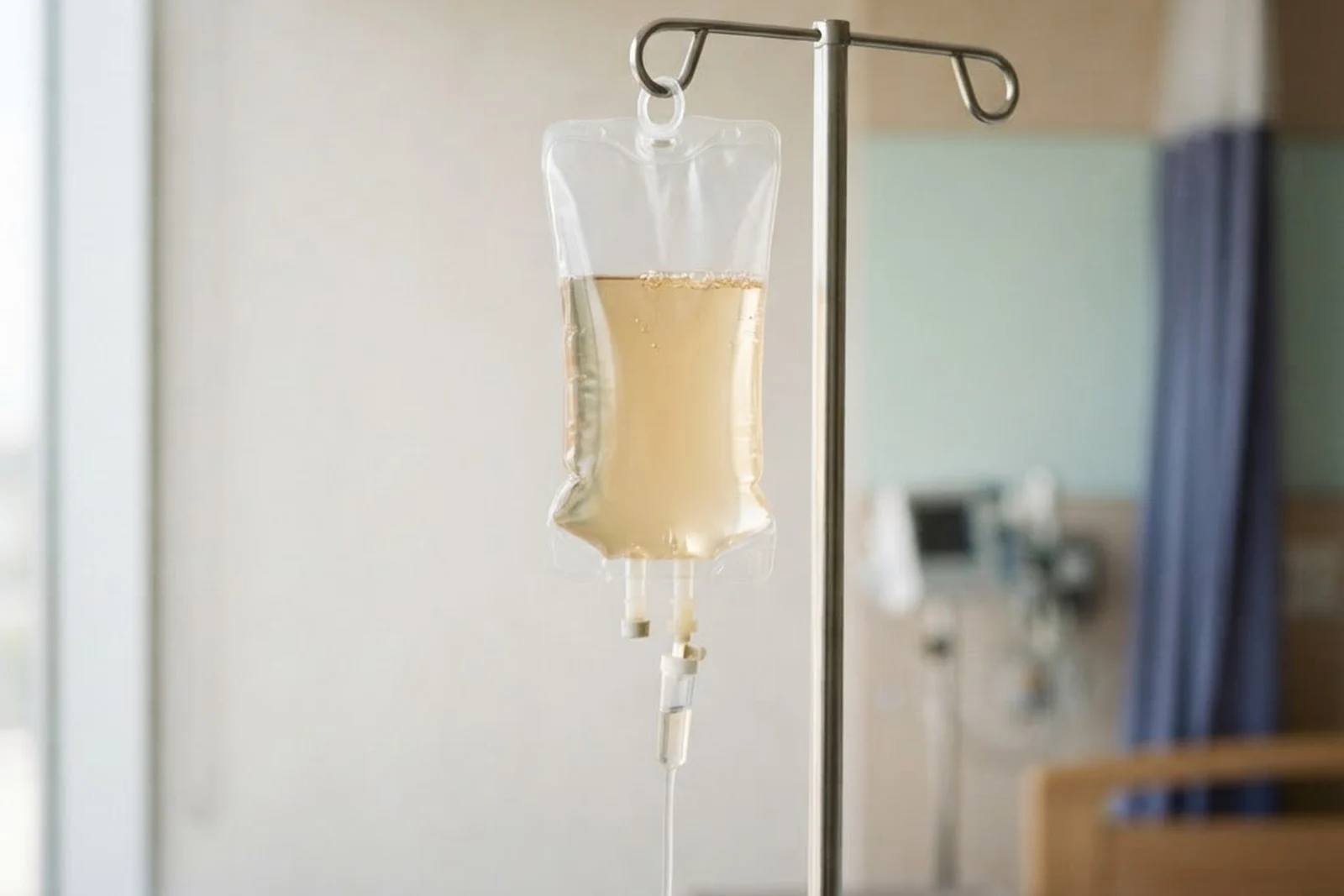An IV bag filled with pale amber vitamin fluid
